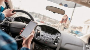 Man holding cell phone while driving