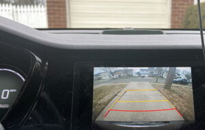 Car backing out of driveway with backup camera
